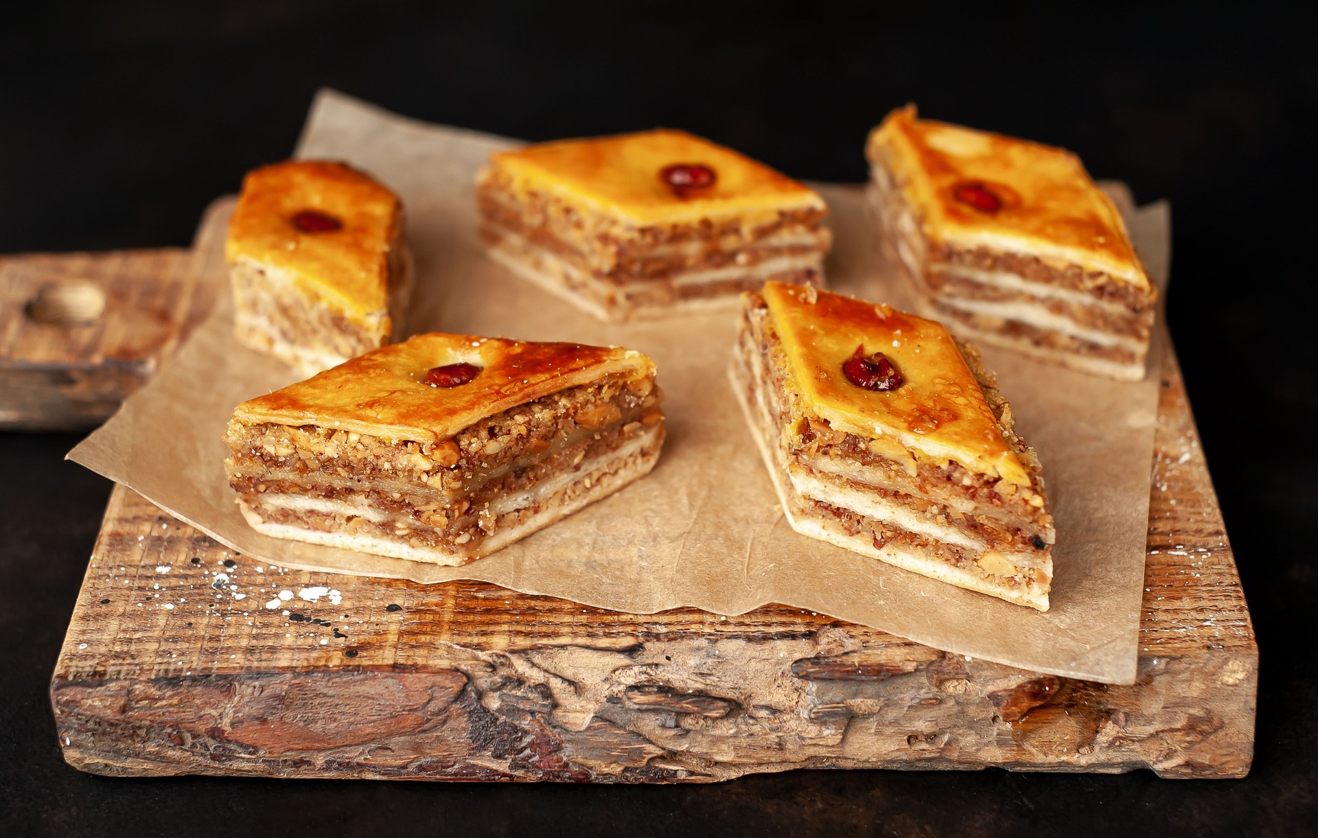 Une pile de gâteaux de miel sur une planche à découper contre un fond de béton